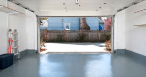 Open garage with concrete flooring and backyard view